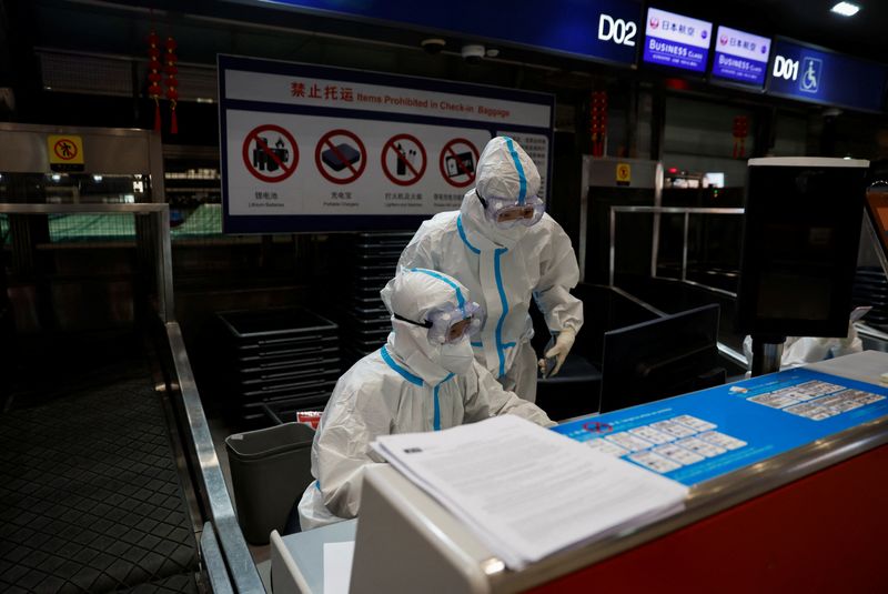 Airline staff wear personal protective equipment to protect against COVID-19,