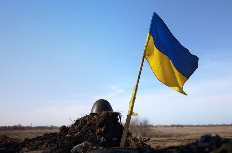 FILE PHOTO: A Ukrainian flag and a helmet of a