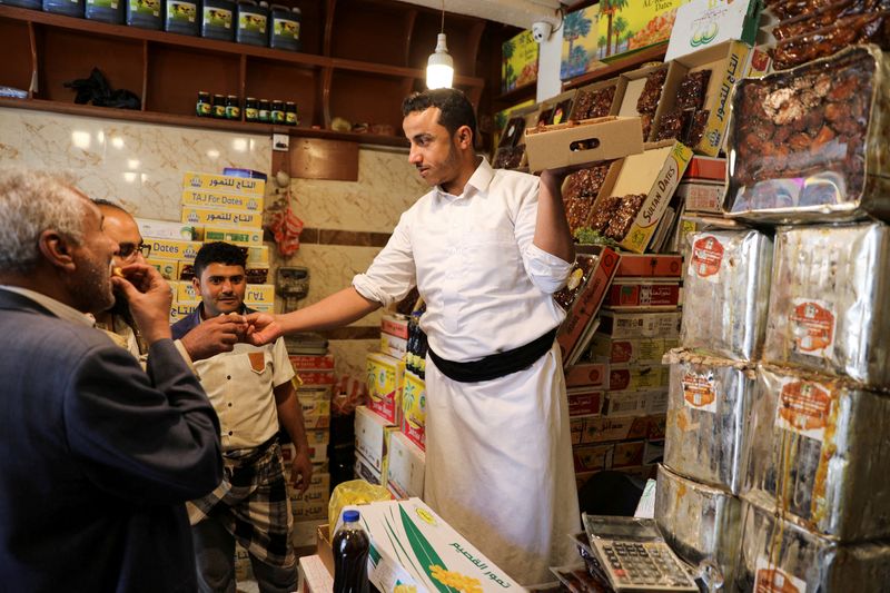 A vendor gives dates to customers to taste as Yemenis