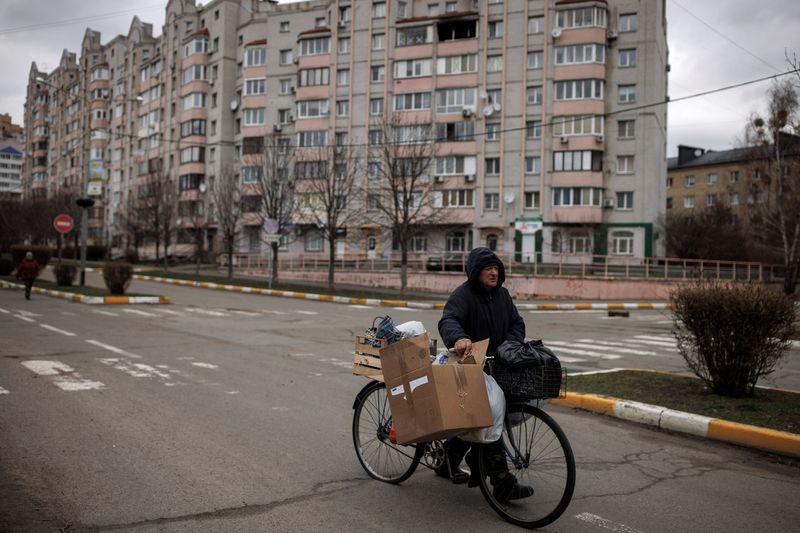 Man pushes his bicycle, amid Russia’s invasion on Ukraine, in