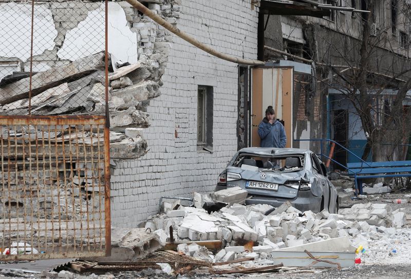 FILE PHOTO: A local resident stands near a damaged apartment