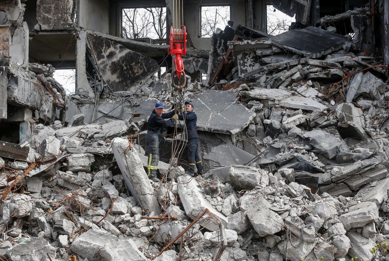 Emergency workers remove debris of a building destroyed in the