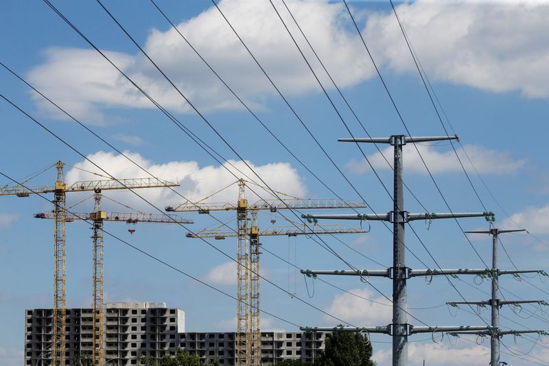 FILE PHOTO: Building cranes and power lines connecting pylons of