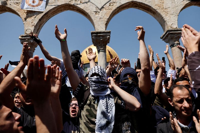 Palestinians shout slogans at the compound that houses Al-Aqsa Mosque,