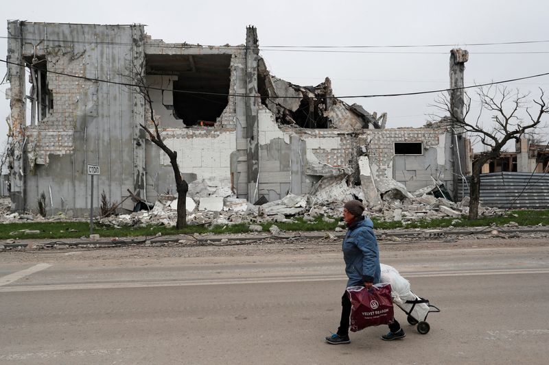 FILE PHOTO: A local resident walks past a destroyed building