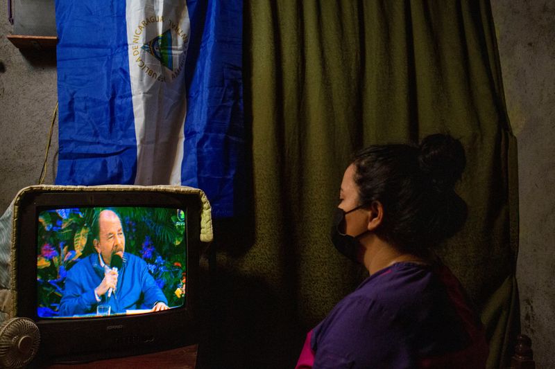 A woman watches a televised speech of Nicaraguan President Daniel