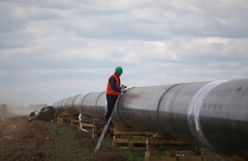A worker is seen next to a pipe at a