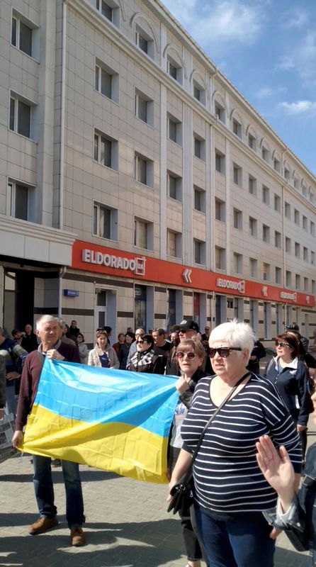 People hold Ukraine’s national flag during a protest where tear