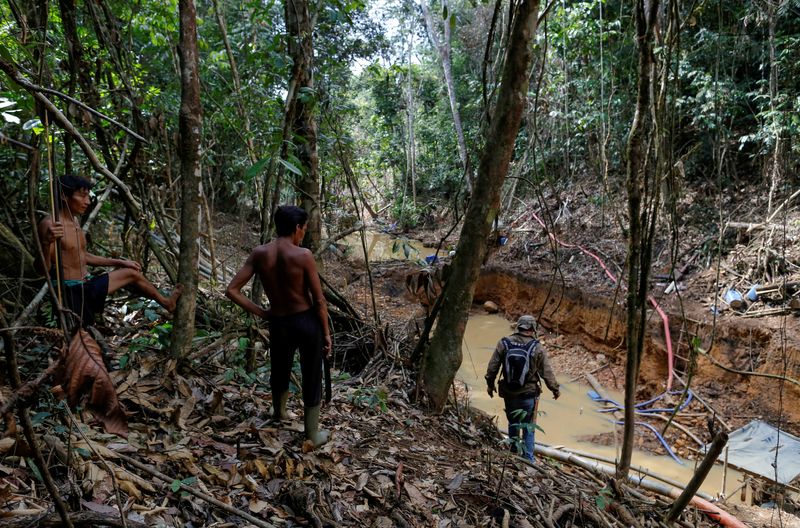 Yanomami indians follow agents of Brazil’s environmental agency in a