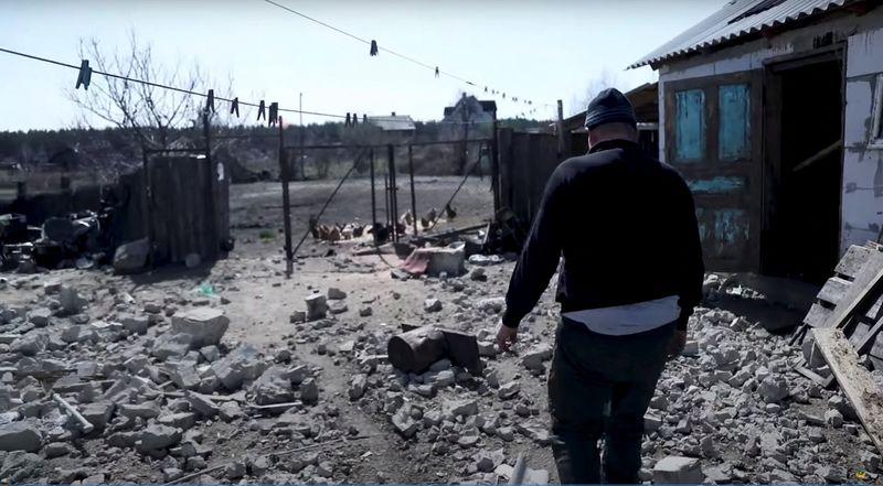 A resident walks among debris, amid Russia’s invasion, in Moshchun