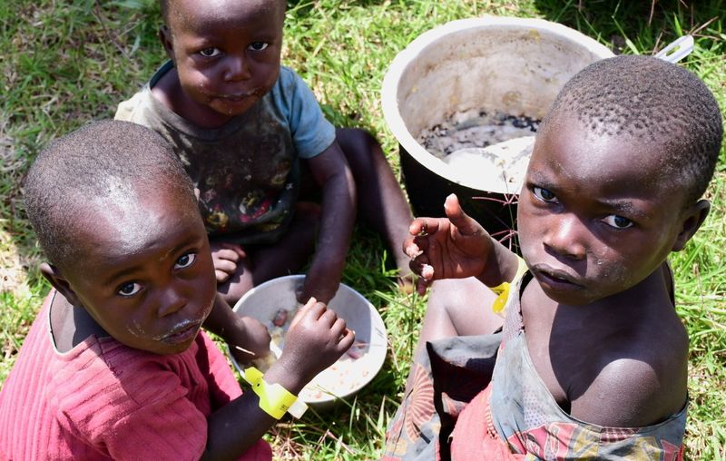 Congolese children share a meal at the Bunagana border crossing