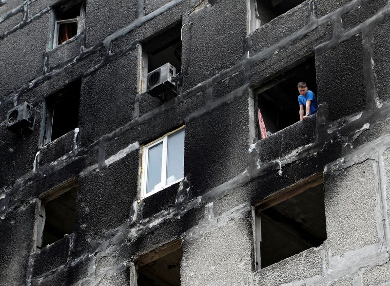 A local resident is seen inside a damaged apartment building