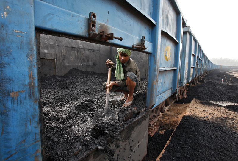 FILE PHOTO: Worker unloads coal from a goods train at