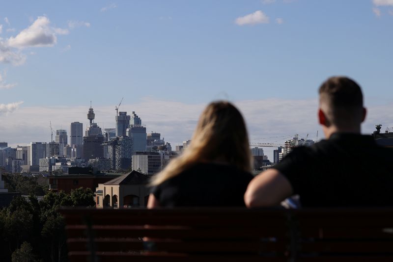 People sitting on a bench at Sydney Park gaze at