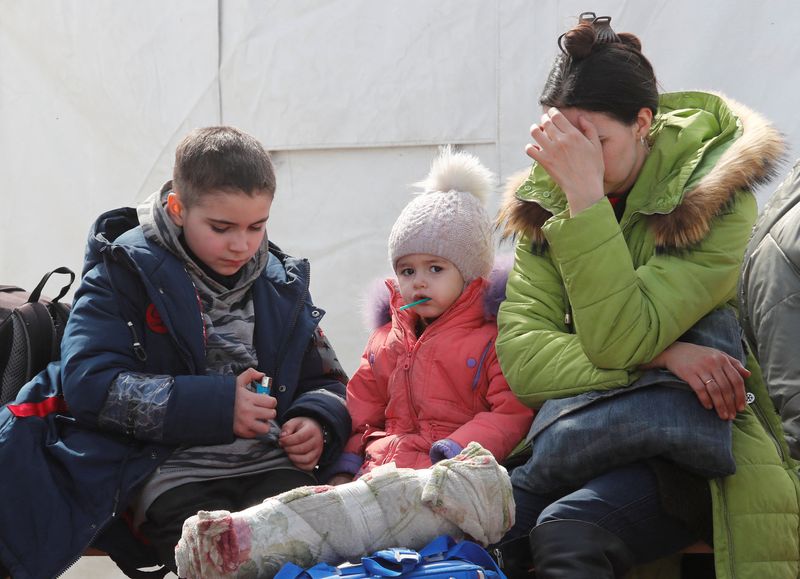 A woman sits with children at a temporary accommodation centre