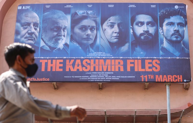 FILE PHOTO: A man walks past a poster of Bollywood