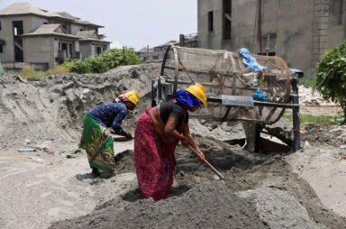 Labourers work at a construction site on a hot summer