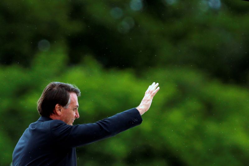 FILE PHOTO: Brazil’s President Jair Bolsonaro gestures before a Flag