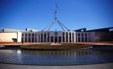 FILE PHOTO: Tourists walk around the forecourt of Australia’s Parliament
