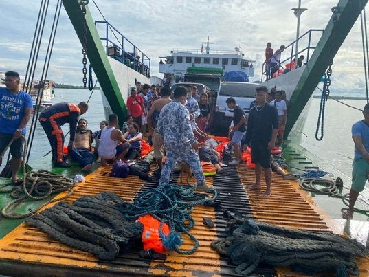 Philippine Coast Guard personnel assist rescued passengers after a passenger
