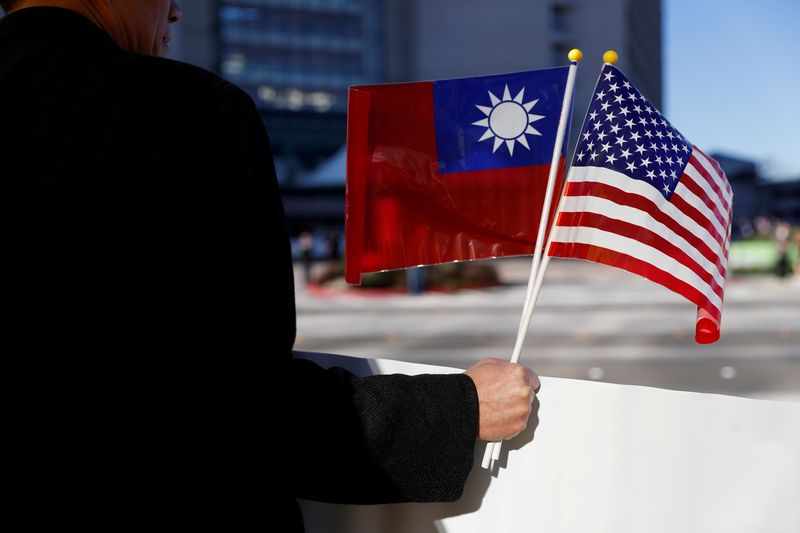A demonstrator holds flags of Taiwan and the United States