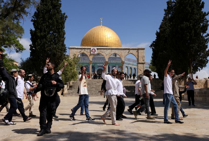 FILE PHOTO: FILE PHOTO: Jewish visitors gesture as Israeli security