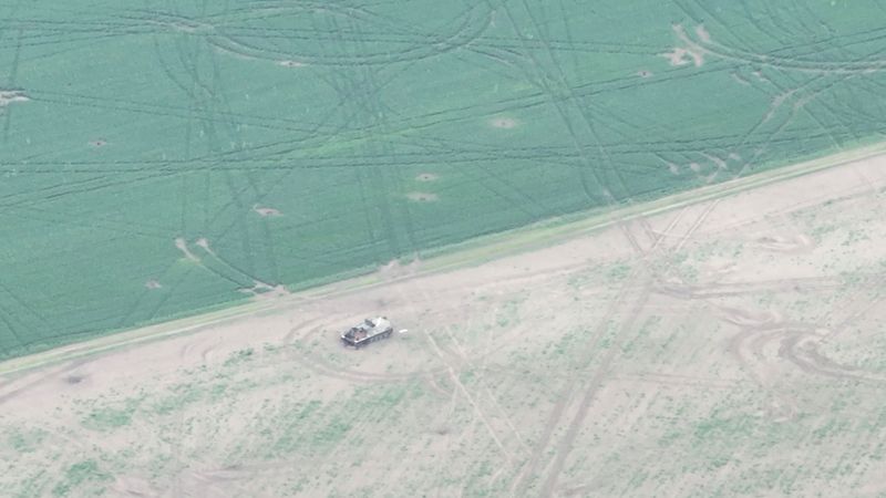 Drone footage shows a military vehicle in a field in