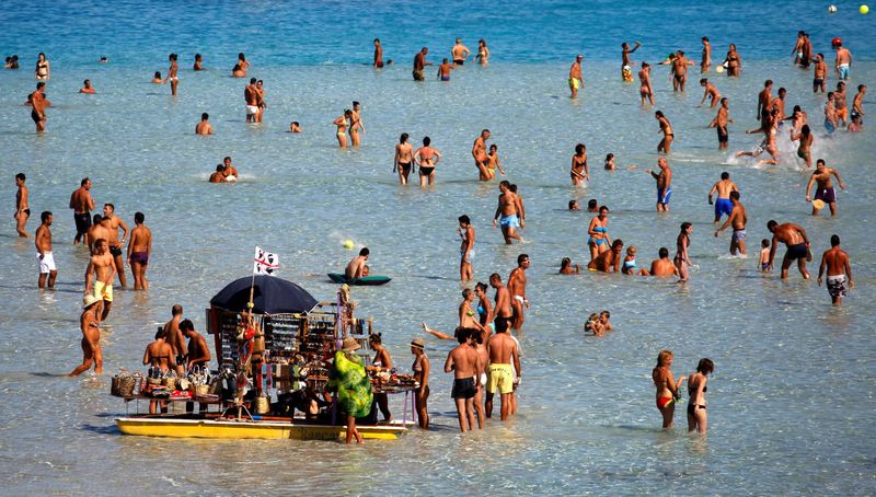 FILE PHOTO: People sunbathe on the beach in the Italian