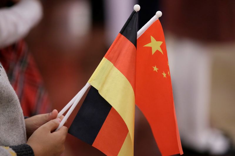 FILE PHOTO: A student holds flags of China and Germany